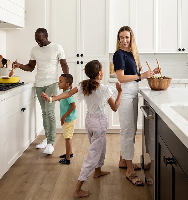 parents and their two children prepare dinner together in their kitchen