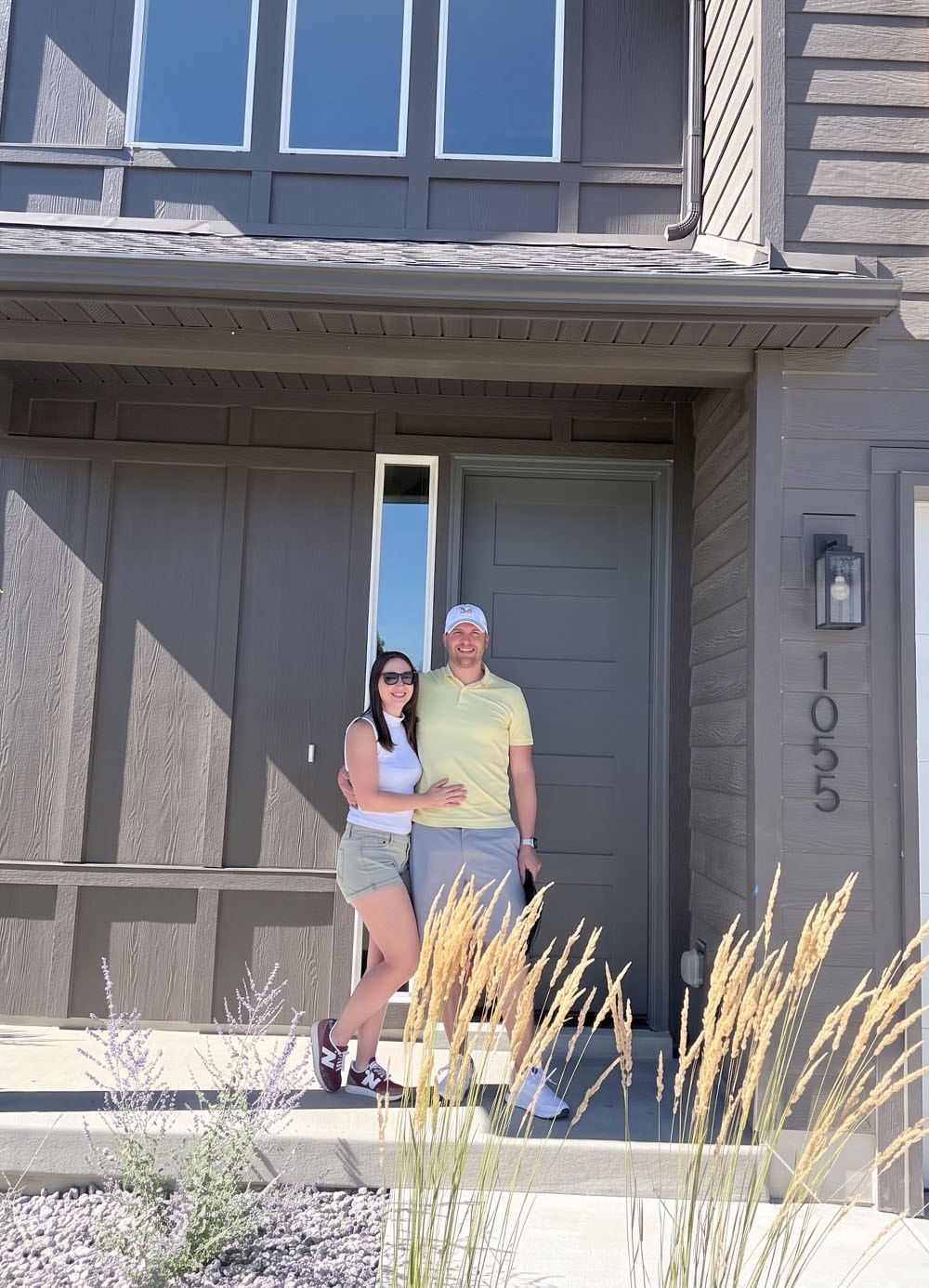 A young couple outside their new home